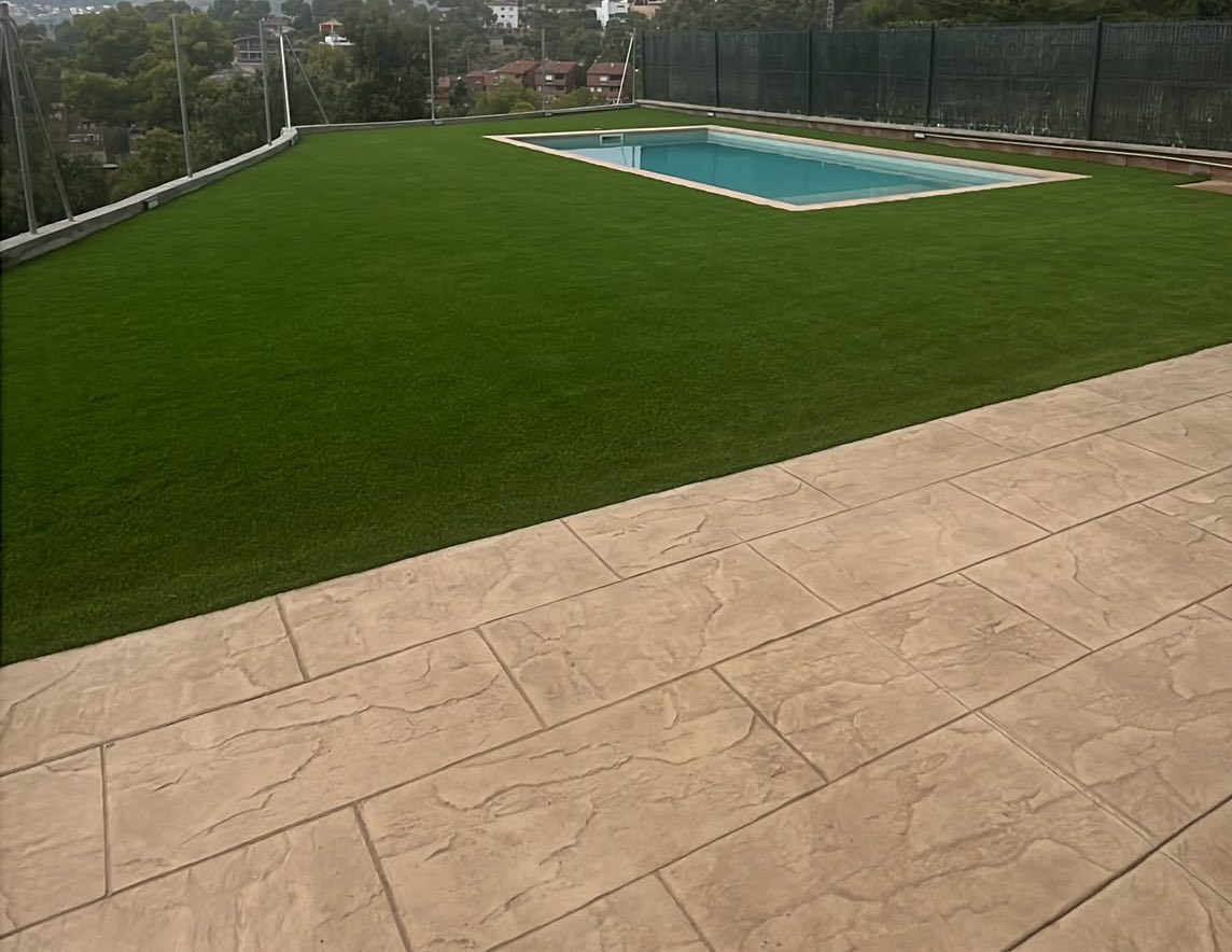 hormigon impreso y cesped artificial para la piscina